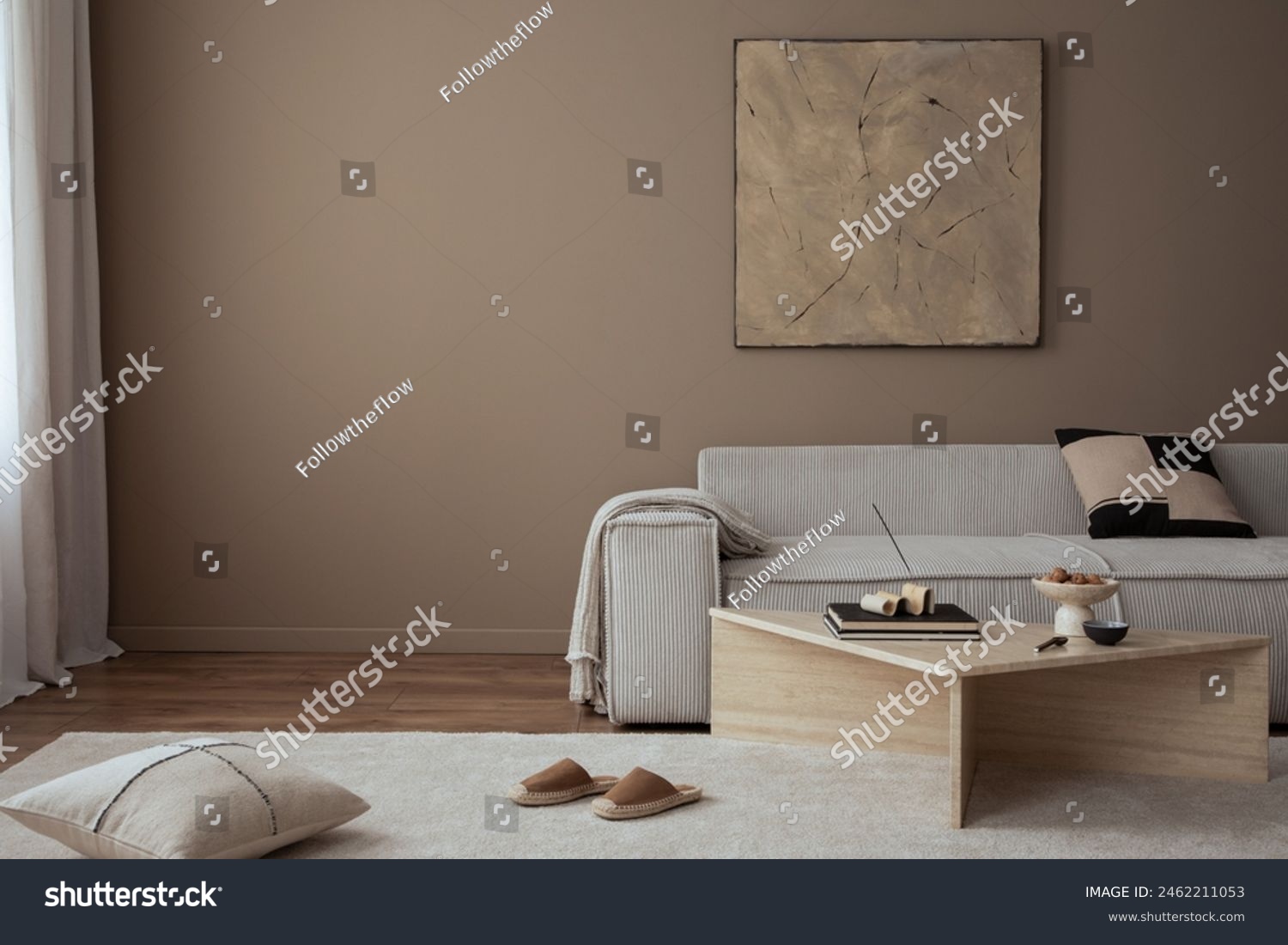 Warm and cozy living room interior with mock up poster frame, painting, beige sofa, travertine coffee table, slippers, bowl with nuts, plaid, pillow and personal accessories. Home decor. Template.