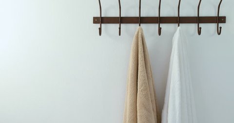 Towels hanging on hook against white wall 4K 4k Stockvideo