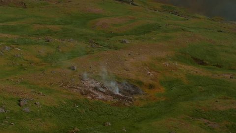 iceland landscape, geothermal hotspring steam smoke valley, camera tilt up , telephoto lens : vidéo de stock