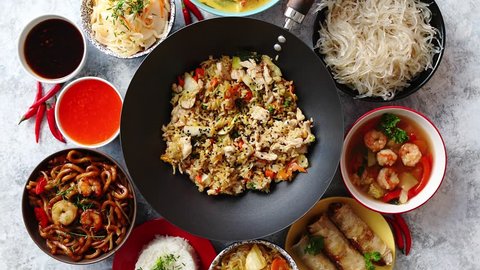 Asian oriental food composition in colorful dishware, served on stone, top view. Chinese, vietnamese, thai cuisine set. With copy space Stock-video