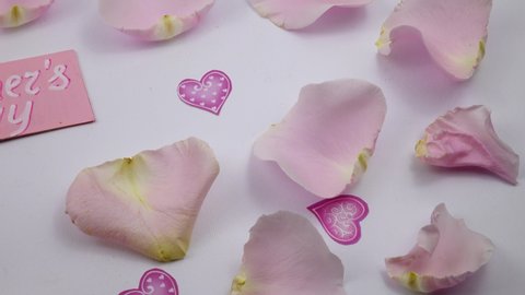 Pale pink rose petals and Mother’s Day card lay out on a white background Stock-video