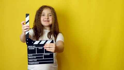 Funny smiling child girl hold film making clapperboard. Copy space for text Video stock