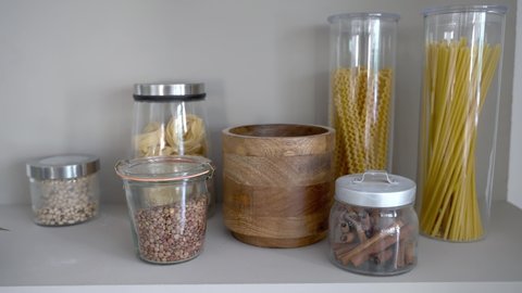 Spaghetti pasta and dry legumes in glass jars on the kitchen shelfの動画素材
