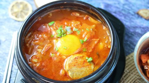 Kimchi stew or Kimchi soup, Korea’s national dish spicy soup with vegetable, meat, eggs, tofu served in a hot pot. Kimchi Jjigae. Stock-video