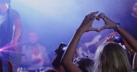 Animation of caucasian woman gesturing heart on concert. party, music and having fun concept digitally generated video. 库存视频