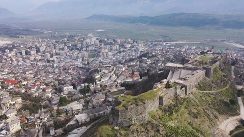  Aerial view of ancient fortified castle of Gjirokaster on rocky hill on background of cityscape in spring, Albania Video stock