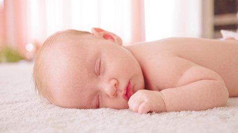 Healthy infant sleeping at home. Beautiful small baby sleeping. Close-up of infant sleeping. Macro shot of a small caucasian baby resting. Shot of napping child, afternoon nap.
の動画素材