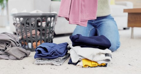 Hands, fold laundry and person with pile of clean clothes in house on living room floor or housekeeper in spring cleaning. Washing, basket and order clothing by color or woman work in home service – Video có sẵn
