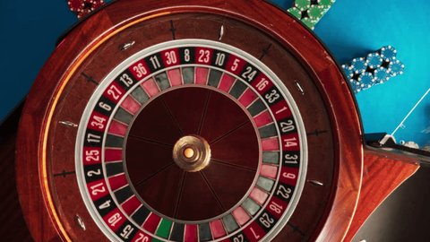Top Down Spinning Shot Of Ball Rolling On Spinning Roulette Table And Falls Into Number Zero Pocket In Luxurious Casino. Chips Are Laying On The Playing Table. Concept of Betting, Gambling, Winning. Video de stock