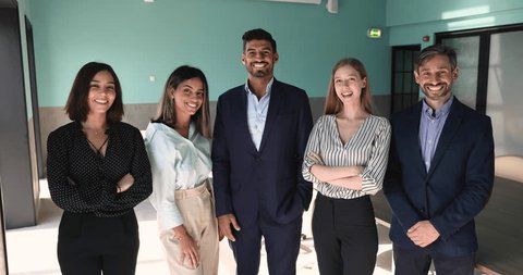 Five motivated young and mature multiethnic staff posing in office, showing team spirit of teamwork and collaboration, having common goals. Success, business achievement, professionalism, competence Vídeo Stock