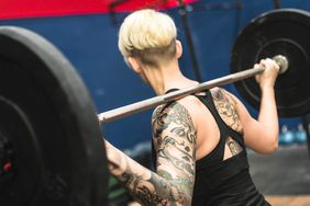 woman doing a strong training with the barbell