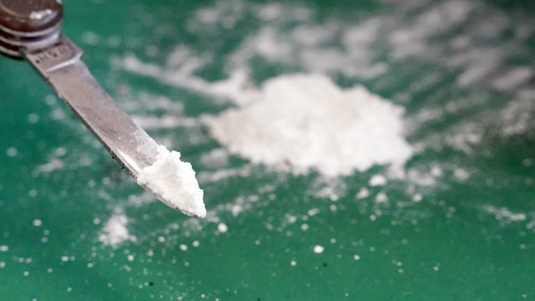 Weißes Pulver auf einer Messerspitze: Polizeibeamte haben bei Kontrollen auf der A7 bei Illertissen (Kreis Neu-Ulm) und Berkheim (Kreis Biberach) insgesamt 28 Kilogramm Kokain sichergestellt.