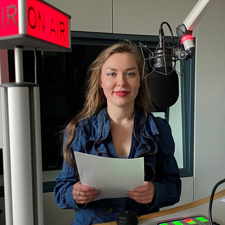 Anna-Carina Blessmann am Mikrofon im Nachrichtenstudio des Studios Trier.