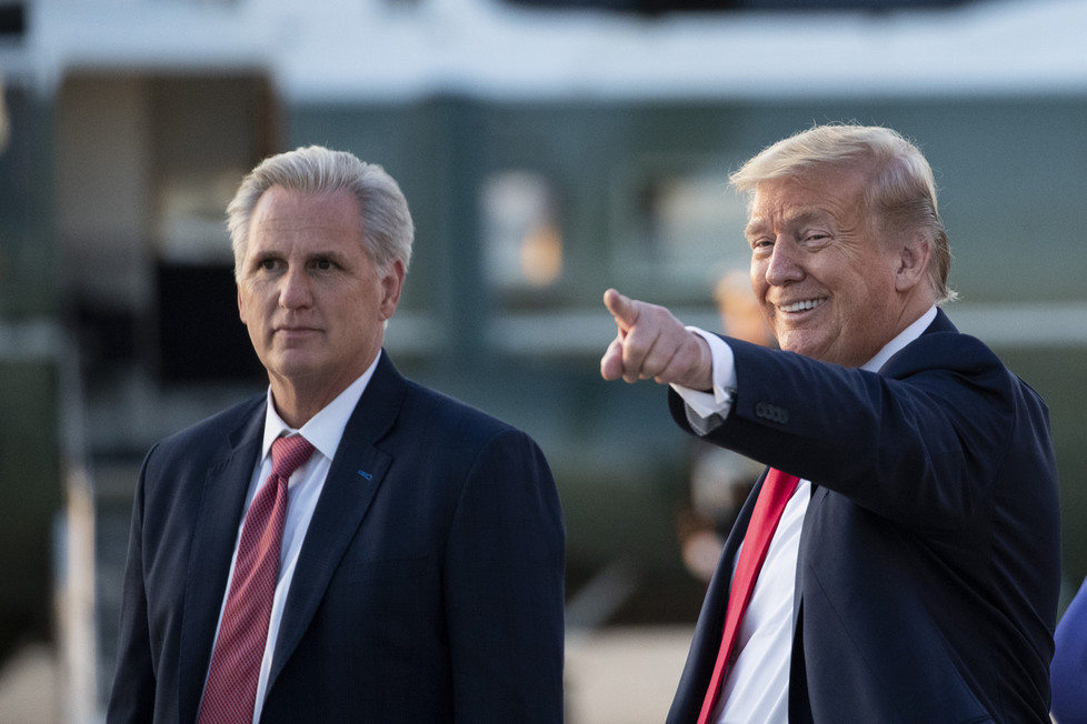 Kevin McCarthy (left) walks with Donald Trump, who is pointing and smiling.
