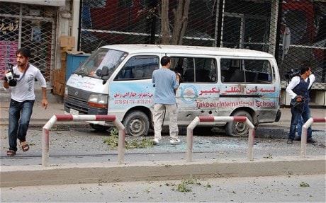Journalists stand near a bullet-ridden mini-van during an on-going attack in Kabul 