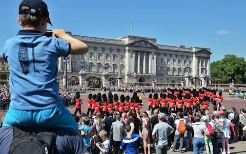  Tourists watch the Changing the Guard ceremony outside Buckingham Palace in London