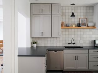 A kitchen with soft gray cabinets and black granite countertop
