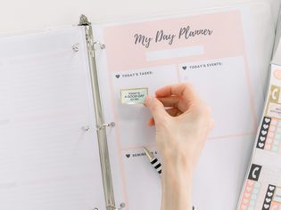 a person placing stickers on a planner page