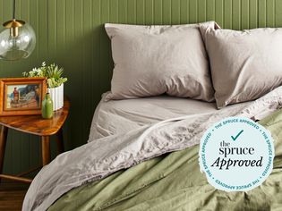 A bed with the Nordstrom at Home Percale Sheet Set on it in a green room.