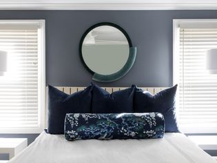 round mirror hanging over bed