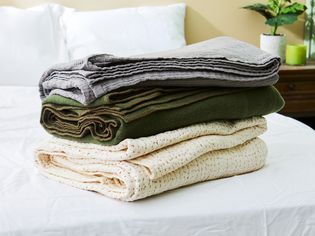 Best blankets folded in a stack on a bed