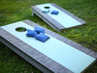 Blue and gray cornhole boards in a yard