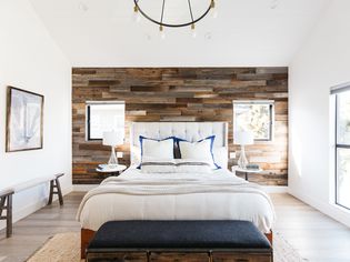 Mixed wood planks covering accent wall in brightly-lit bedroom 