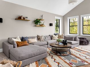 Beautiful living room interior with colorful area rug, large couch, and abundant natural ligh