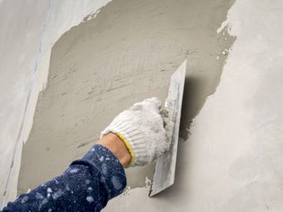 Close-up of plastering wet cement on the wall