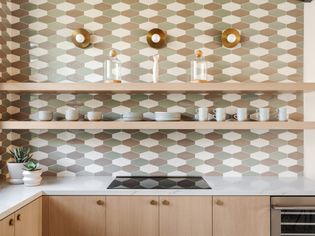Open shelves in a kitchen with bold wall tile and minimalist lights