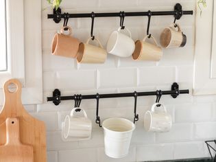 mugs hanging from hooks on the wall