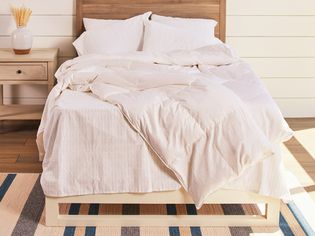 Brooklinen Down Comforter on a bed next to a night stand