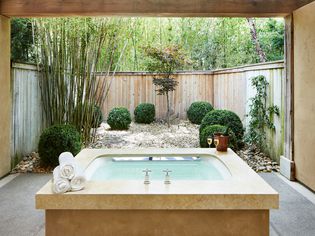a hot tub centrally placed between fences and walls