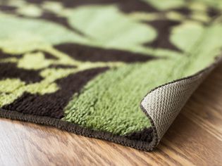Brown and green rug with corner curled up