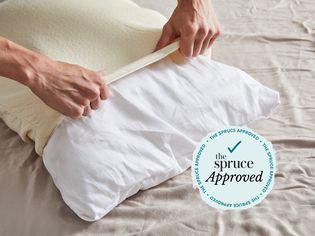 A person putting a pillowcase on the Birch by Helix Organic Pillow