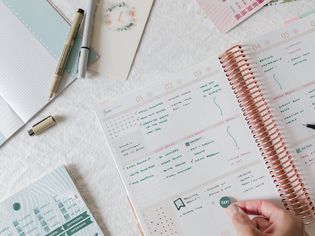 Bullet journal written in green ink with reminder sticker being placed
