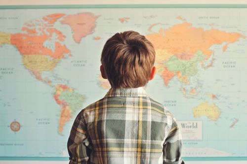 A child looking at a world map.