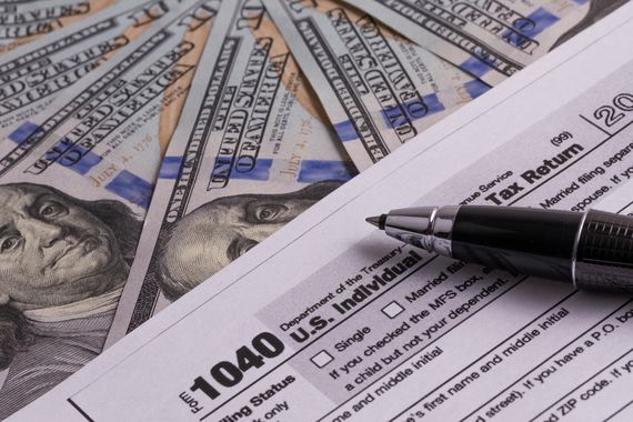 US Tax Return Form 1040 and 100 USD Bills