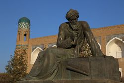 Statue of Al-Khwarizmi in Khiva against a blue sky.