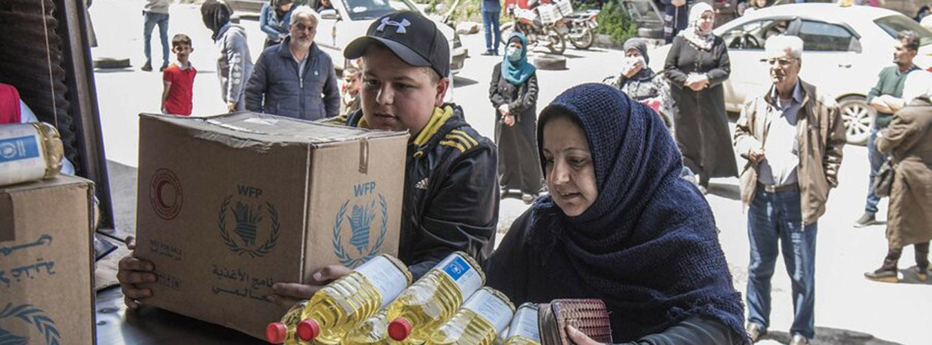 عائلة تحصل على الطعام من مركز توزيع برنامج الغذاء العالمي في سوريا.