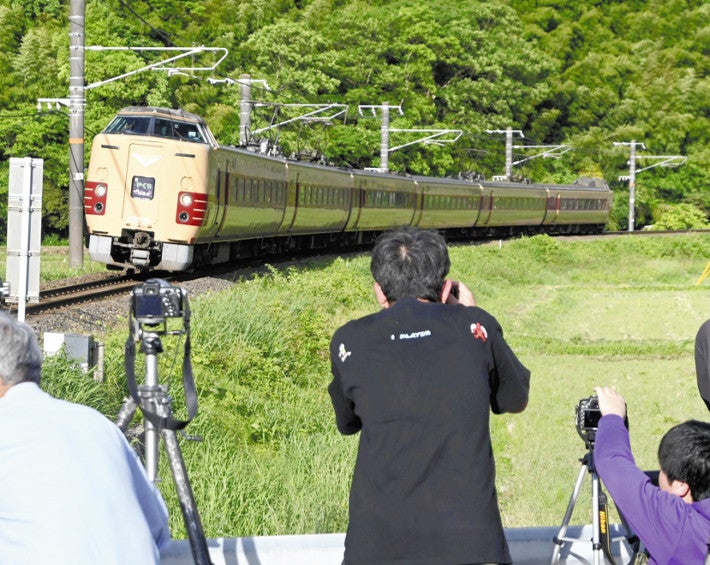 「国鉄色」に塗装された「３８１系」。道路脇から鉄道ファンらがカメラを構える（１８日、鳥取県日野町で）＝東大貴撮影