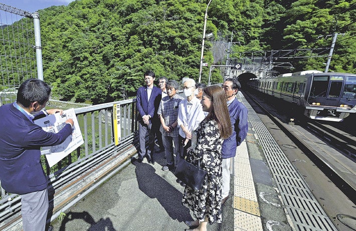 駅ホームでエレベーター設置について説明を受ける兵庫県の斎藤知事（左から２人目）や地元関係者ら（兵庫県宝塚市で）