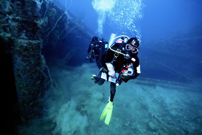 「愛国丸」の船内で収容した遺骨を抱え、浮上する潜水士（１５日、ミクロネシア連邦・チューク州で）＝加藤学撮影