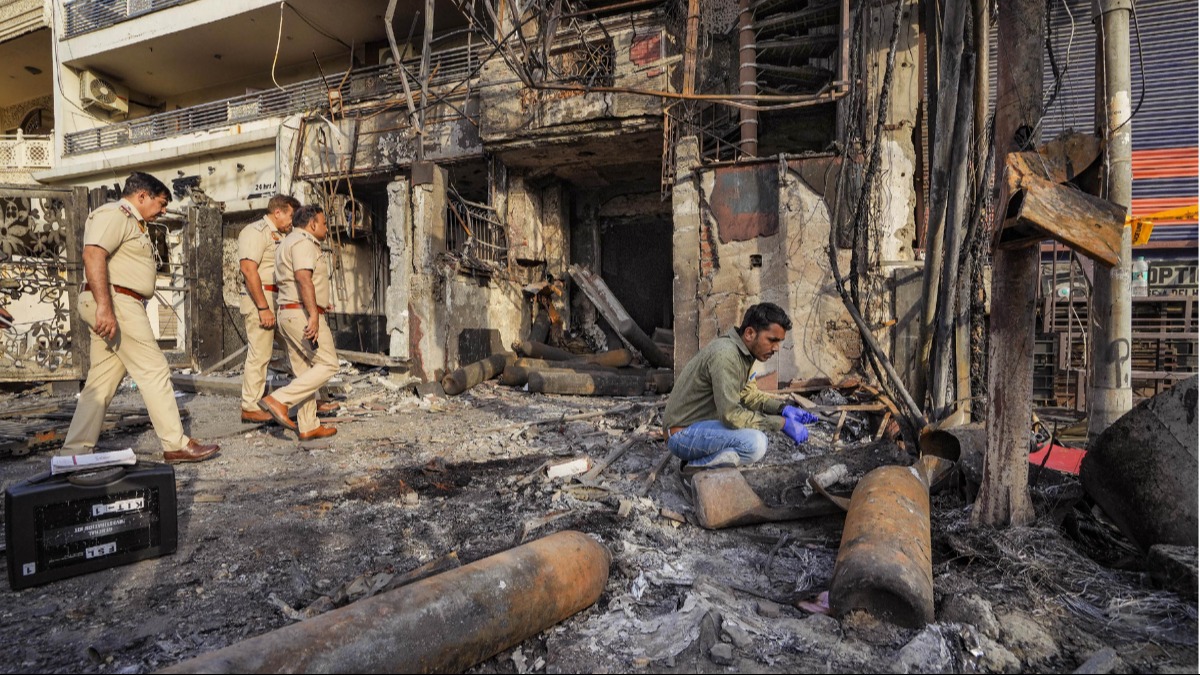 A forensic expert collects samples from site of the fire at the New Born Baby Care Hospital in east Delhi