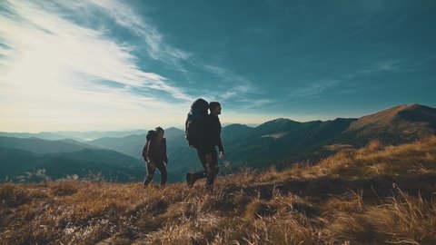 The couple walking on the mountain on a sunny background. slow motion : vidéo de stock