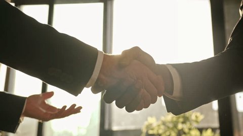 Close up male hands handshaking in sunny office. Multiethnic Caucasian and African business people diverse men businessmen shaking arms successful partnership deal cooperation agreement handshake - Βίντεο στοκ