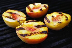 Fresh peaches cooked on a grill with grill marks