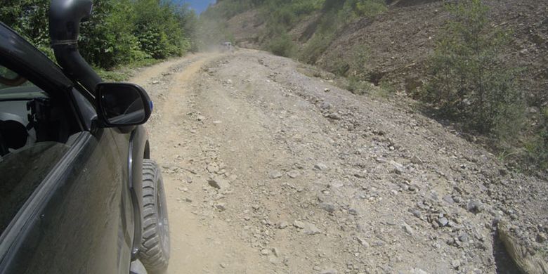 Mobil penggerak empat roda melewati jalan yang rusak di Pegunungan Arfak, Papua Barat, Kamis (16/8/2018). Akses jalan rusak menuju Pegunungan Arfak dari Manokwari adalah tantangan untuk pengembangan pariwisata Pegunungan Arfak.
