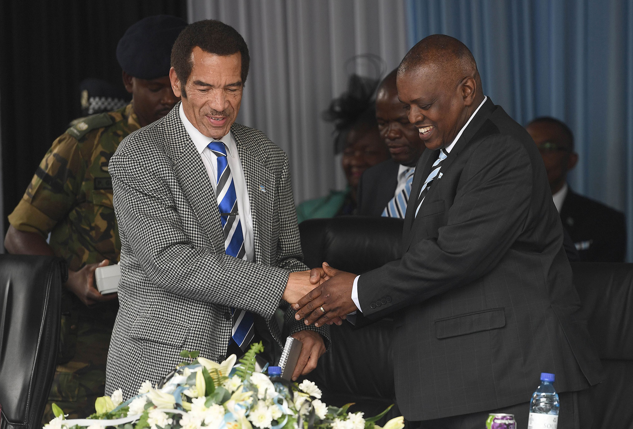 Ian Khama, left, shakes hands with Mokgweetsi Masisi.