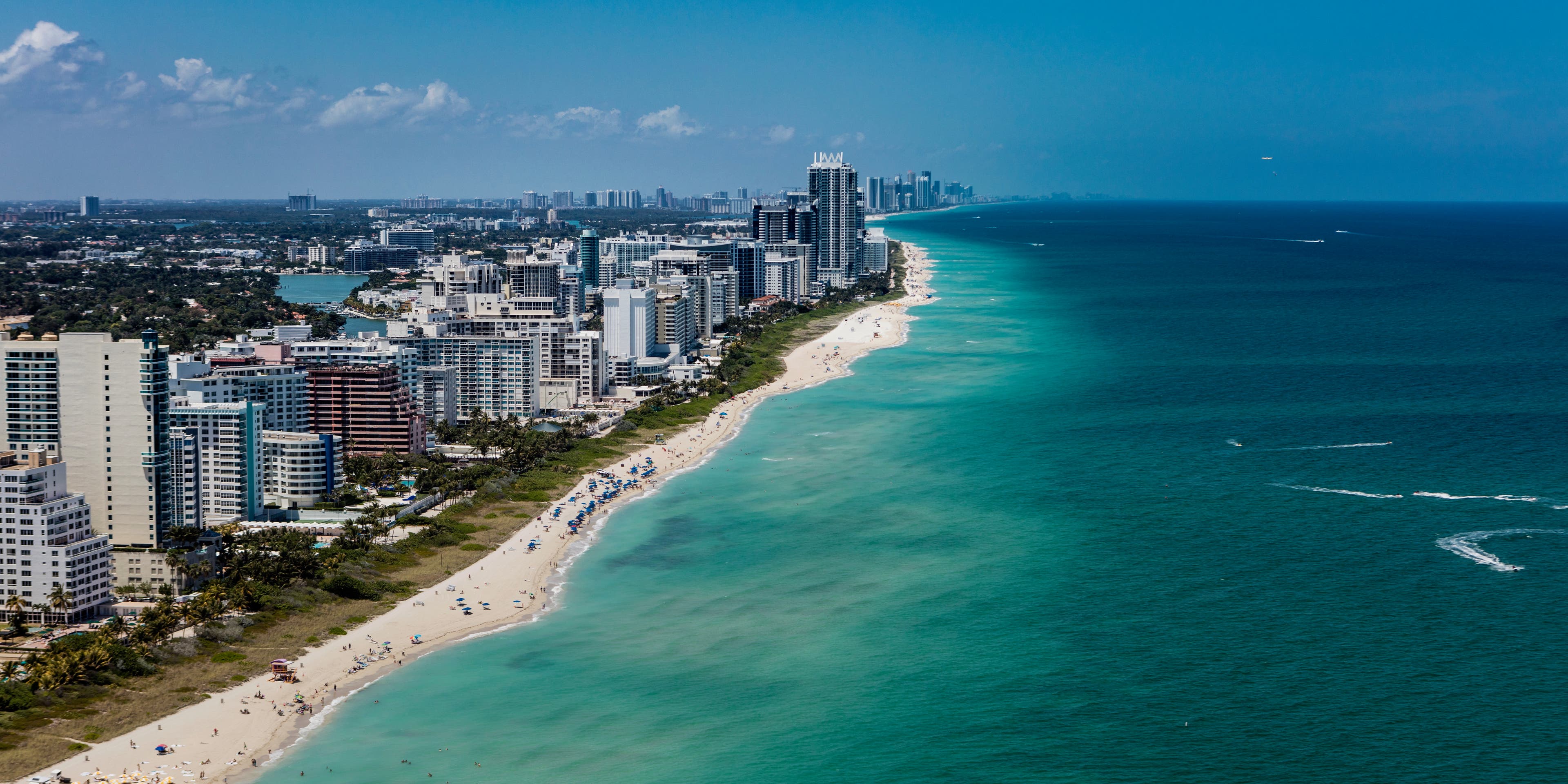 Aerial view of South Beach Miami Florida cityscape with buildings along the beach on a beautiful sunny day, people on beach and ocean.